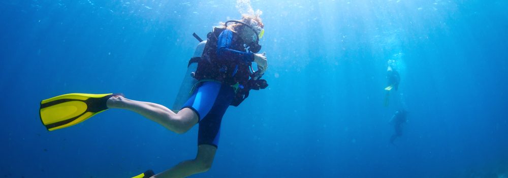 Underwater shoot of a divers swimming in a blue clear water